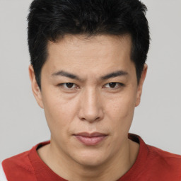 Joyful asian young-adult male with short  brown hair and brown eyes