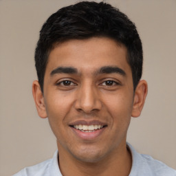 Joyful latino young-adult male with short  black hair and brown eyes