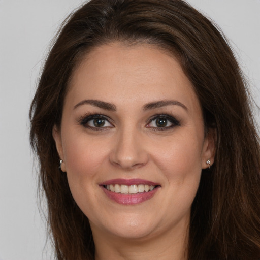 Joyful white young-adult female with long  brown hair and brown eyes