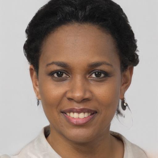 Joyful black young-adult female with short  brown hair and brown eyes
