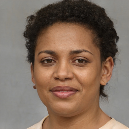 Joyful black adult female with short  brown hair and brown eyes