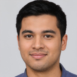 Joyful latino young-adult male with short  black hair and brown eyes