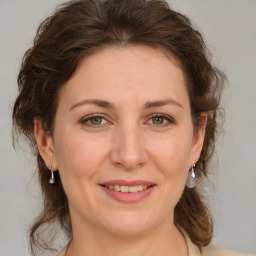 Joyful white adult female with medium  brown hair and grey eyes