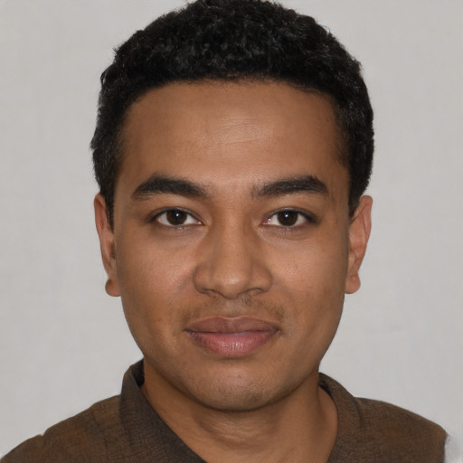 Joyful black young-adult male with short  black hair and brown eyes