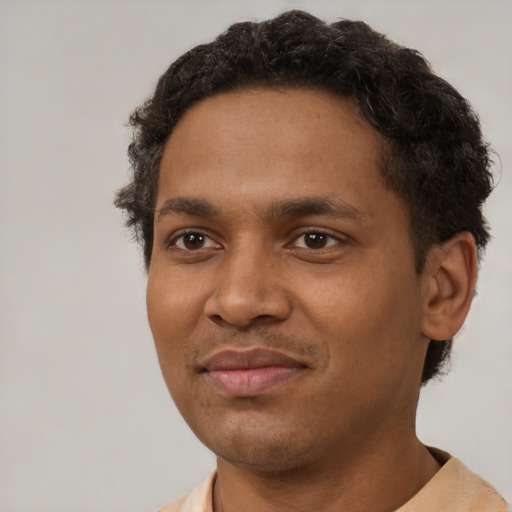 Joyful black young-adult male with short  brown hair and brown eyes