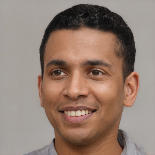 Joyful latino young-adult male with short  black hair and brown eyes