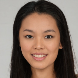 Joyful asian young-adult female with long  brown hair and brown eyes