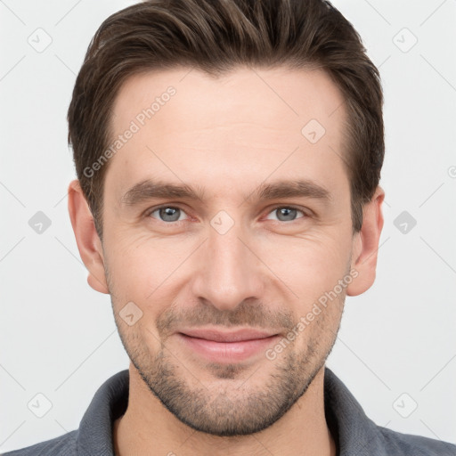 Joyful white young-adult male with short  brown hair and grey eyes