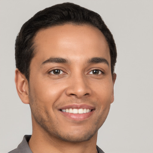 Joyful latino young-adult male with short  brown hair and brown eyes