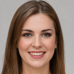 Joyful white young-adult female with long  brown hair and green eyes