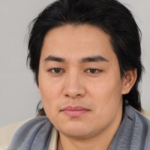 Joyful asian young-adult male with medium  brown hair and brown eyes