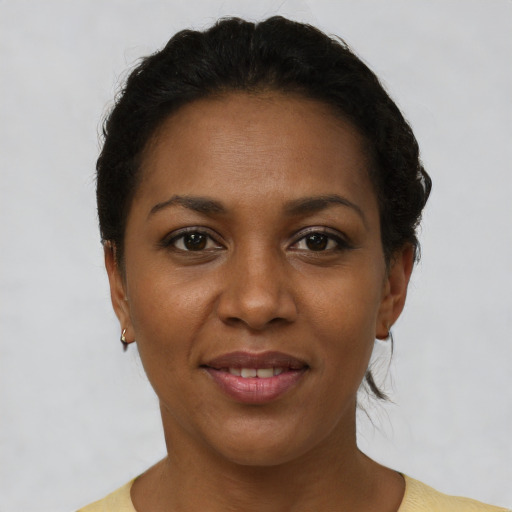 Joyful black young-adult female with short  brown hair and brown eyes