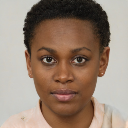 Joyful black young-adult female with short  brown hair and brown eyes
