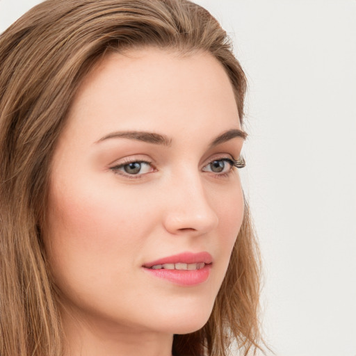 Joyful white young-adult female with long  brown hair and blue eyes