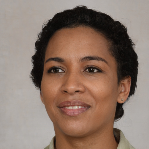 Joyful black young-adult female with short  black hair and brown eyes