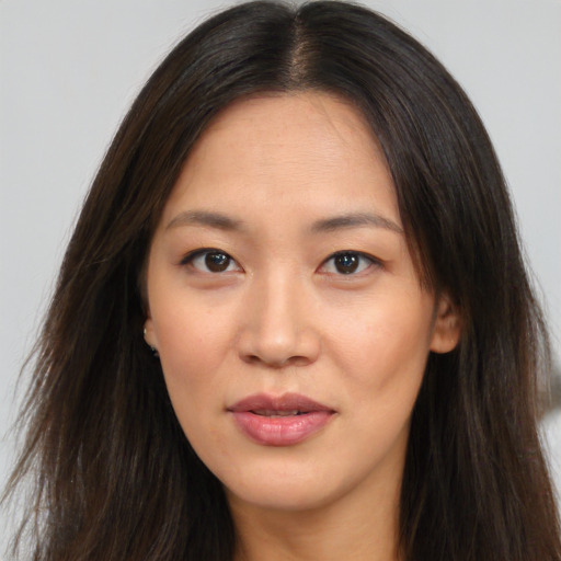 Joyful asian young-adult female with long  brown hair and brown eyes