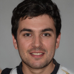 Joyful white young-adult male with short  black hair and brown eyes