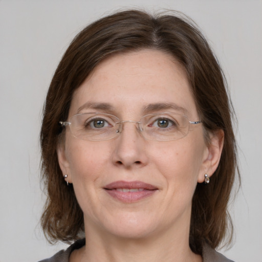 Joyful white adult female with medium  brown hair and grey eyes