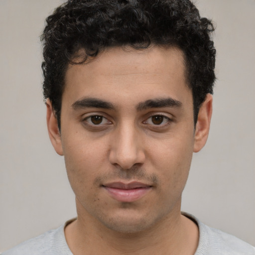 Joyful latino young-adult male with short  brown hair and brown eyes