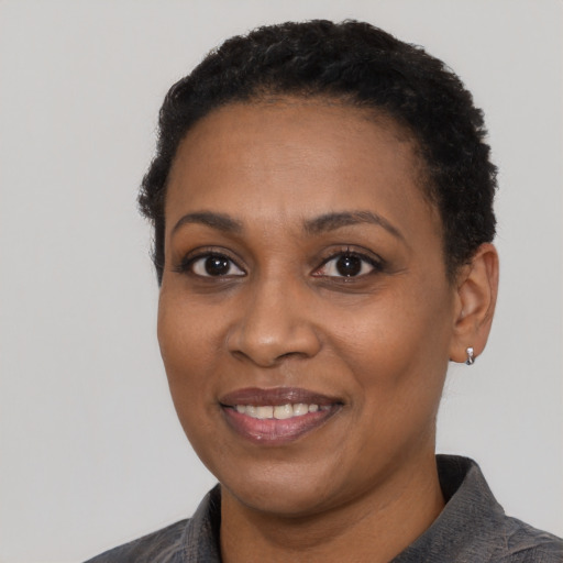 Joyful black young-adult female with short  black hair and brown eyes