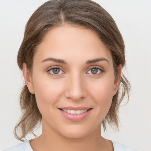 Joyful white young-adult female with medium  brown hair and grey eyes