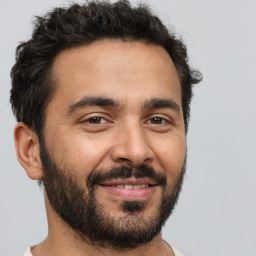 Joyful latino young-adult male with short  brown hair and brown eyes