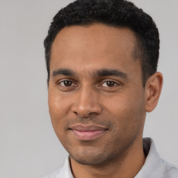 Joyful latino young-adult male with short  black hair and brown eyes