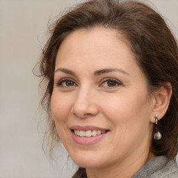 Joyful white adult female with medium  brown hair and brown eyes