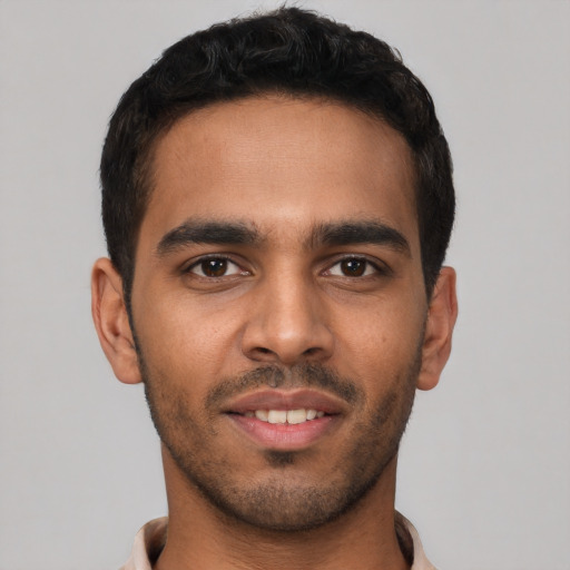 Joyful latino young-adult male with short  black hair and brown eyes