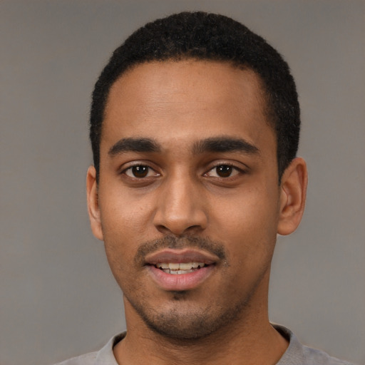 Joyful black young-adult male with short  black hair and brown eyes