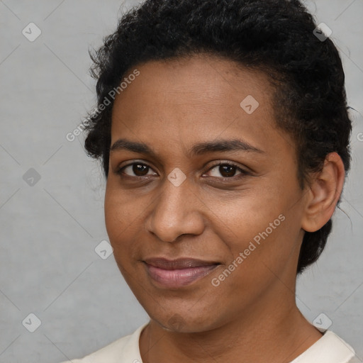 Joyful black young-adult female with short  brown hair and brown eyes