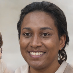 Joyful latino adult female with medium  brown hair and brown eyes