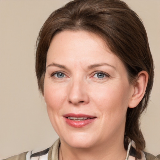 Joyful white adult female with medium  brown hair and blue eyes