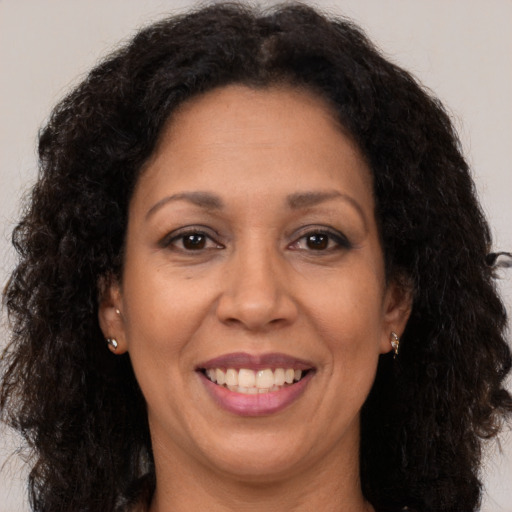Joyful latino adult female with long  brown hair and brown eyes