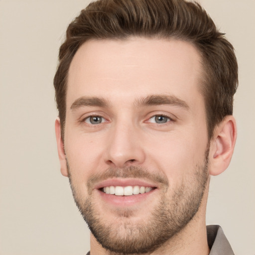 Joyful white young-adult male with short  brown hair and grey eyes