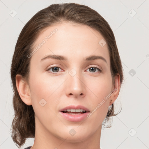 Joyful white young-adult female with medium  brown hair and grey eyes