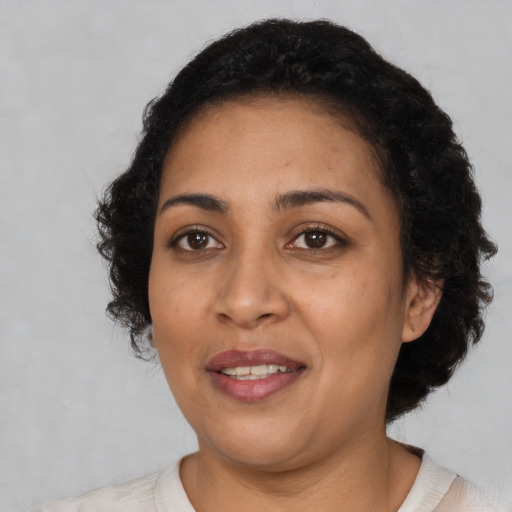 Joyful latino adult female with short  black hair and brown eyes