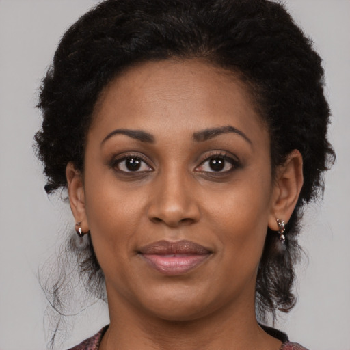Joyful black young-adult female with medium  black hair and brown eyes