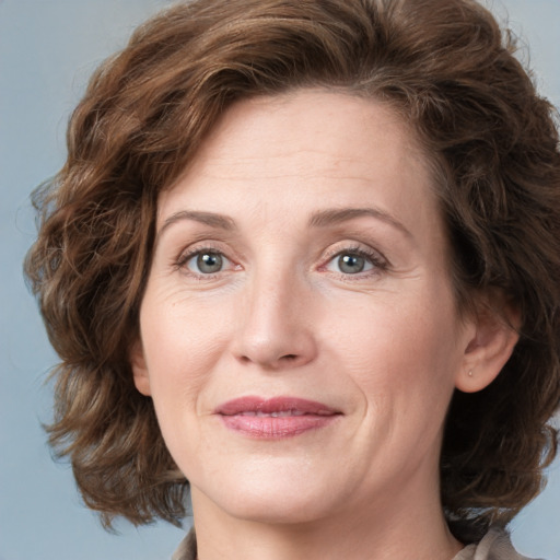 Joyful white adult female with medium  brown hair and grey eyes