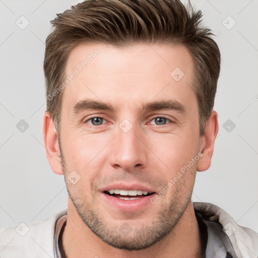 Joyful white young-adult male with short  brown hair and grey eyes