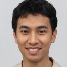 Joyful white young-adult male with short  black hair and brown eyes