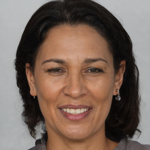 Joyful latino adult female with medium  brown hair and brown eyes