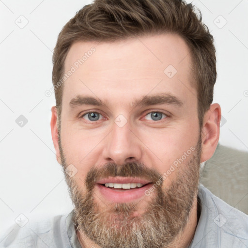 Joyful white young-adult male with short  brown hair and grey eyes