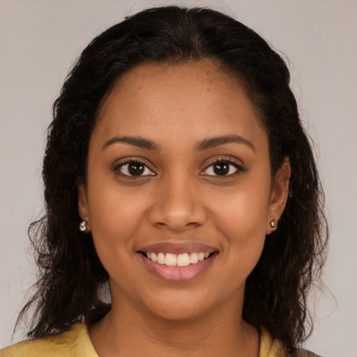 Joyful black young-adult female with long  brown hair and brown eyes