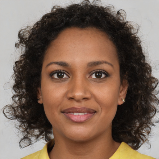 Joyful black young-adult female with medium  brown hair and brown eyes