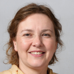 Joyful white adult female with medium  brown hair and blue eyes