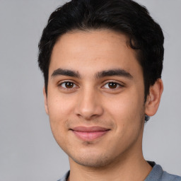 Joyful white young-adult male with short  black hair and brown eyes