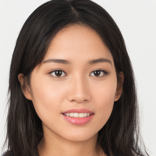 Joyful asian young-adult female with long  brown hair and brown eyes