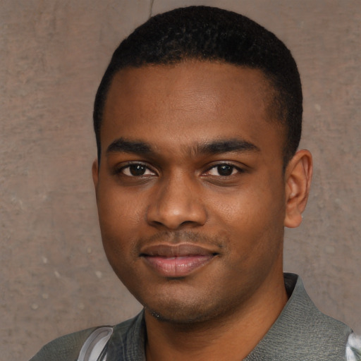 Joyful black young-adult male with short  black hair and brown eyes