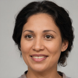 Joyful latino adult female with medium  brown hair and brown eyes